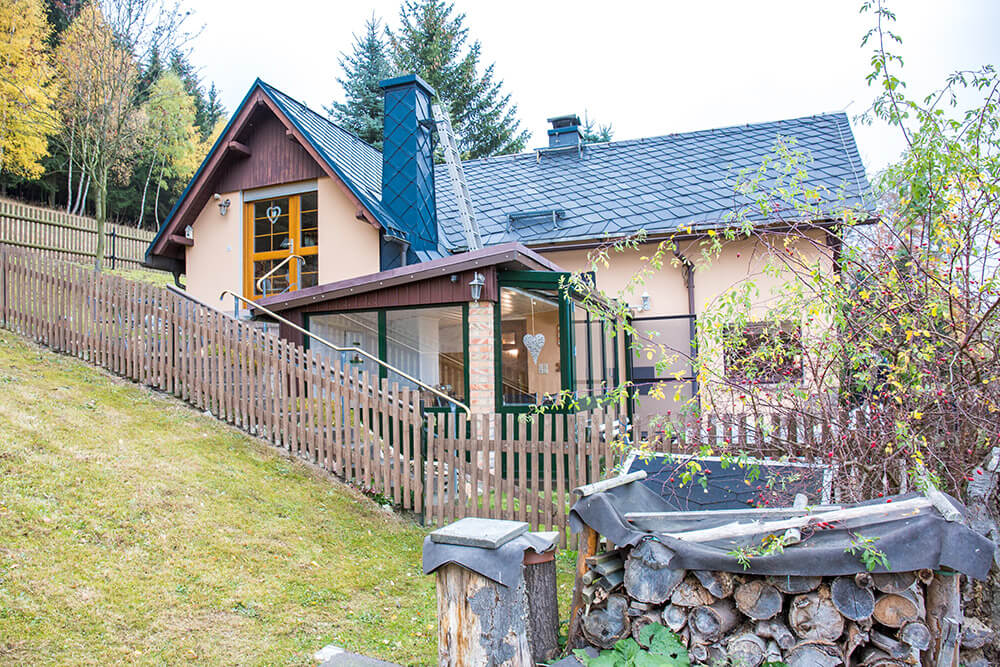 Außenansicht Ferienhaus Erna mit Holzplatz im Vordergrund